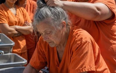 An elderly inmate quietly washed her clothes in the prison yard